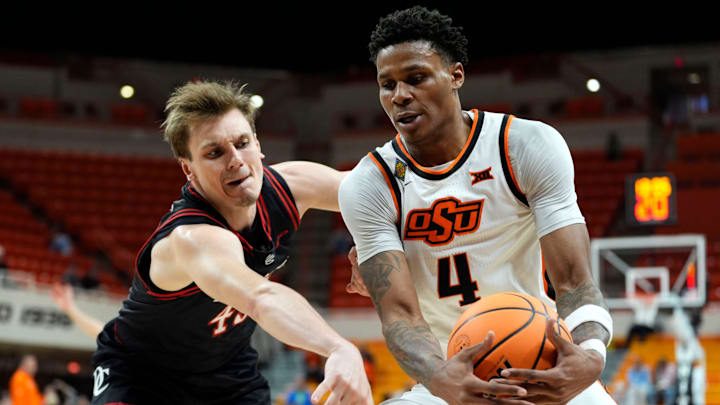 Oklahoma State Cowboys forward Christian Coleman (4) gathers the ball beside Davidson Wildcats guard Roberts Blums (45) during a first-round basketball game in the National Invitational between the Oklahoma State Cowboys and the Davidson Wildcats at Gallagher-Iba Arena in Stillwater, Okla., Tuesday, March 17, 2026. Oklahoma State Cowboys forward Christian Coleman (4) gathers the ball beside Davidson Wildcats guard Roberts Blums (45) during a first-round basketball game in the National Invitational between the Oklahoma State Cowboys and the Davidson Wildcats at Gallagher-Iba Arena in Stillwater, Okla., Tuesday, March 17, 2026.