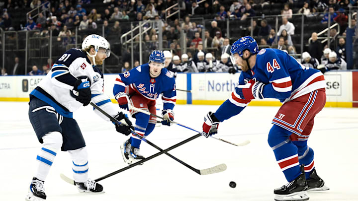 Mar 22, 2026; New York, New York, USA; Winnipeg Jets left wing Kyle Connor (81) passes the puck while defended by New York Rangers defenseman Vladislav Gavrikov (44) during the first period at Madison Square Garden. Mandatory Credit: John Jones-Imagn Images