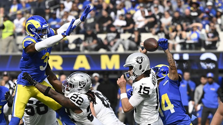 Oct 20, 2024; Inglewood, California, USA; Los Angeles Rams cornerback Cobie Durant (14) knocks the ball out of the hands of Las Vegas Raiders quarterback Gardner Minshew (15) during the second quarter at SoFi Stadium. The ball was recovered by Los Angeles Rams safety Kamren Curl (3) and runback for a touchdown. Mandatory Credit: Robert Hanashiro-Imagn Images