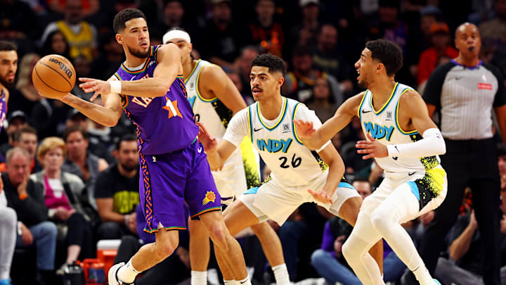 Dec 19, 2024; Phoenix, Arizona, USA; Phoenix Suns guard Devin Booker (1) passes the ball against Indiana Pacers guard Ben Sheppard (26) and guard Tyrese Haliburton (0) during the first quarter at Footprint Center. Mandatory Credit: Mark J. Rebilas-Imagn Images