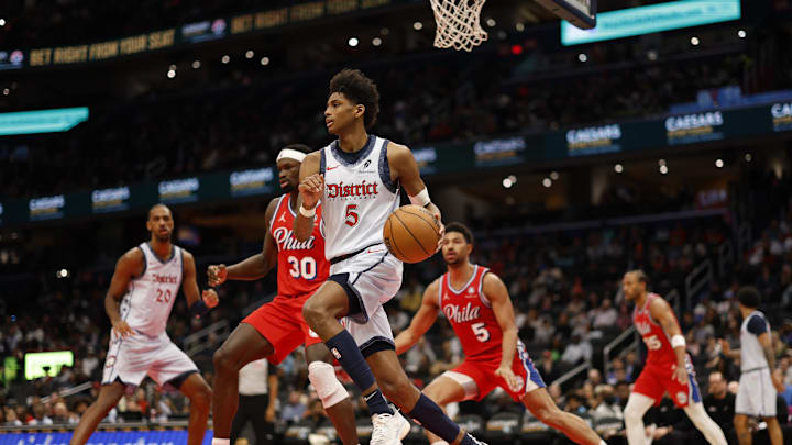 Apr 9, 2025; Washington, District of Columbia, USA; Washington Wizards guard AJ Johnson (5) dribbles the ball as Philadelphia 76ers center Adem Bona (30) defends in the second half at Capital One Arena. Mandatory Credit: Geoff Burke-Imagn Images