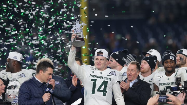 Dec 27, 2019; Bronx, New York, USA; Michigan State quarterback Brian Lewerke (14) holds up the MVP trophy after defeating the Wake Forest Demon Deacons in the Pinstripe Bowl at Yankee Stadium. Mandatory Credit: Brad Penner-USA TODAY Sports