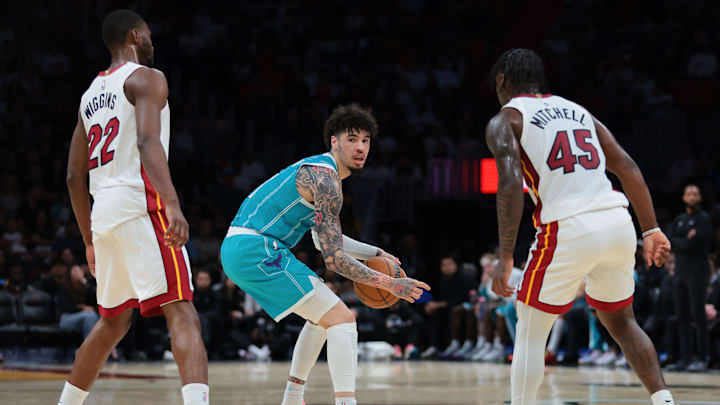 Oct 28, 2025; Miami, Florida, USA; Charlotte Hornets guard LaMelo Ball (1) protects the basketball from Miami Heat forward Andrew Wiggins (22) and guard Davion Mitchell (45) during the second quarter at Kaseya Center. Mandatory Credit: Sam Navarro-Imagn Images