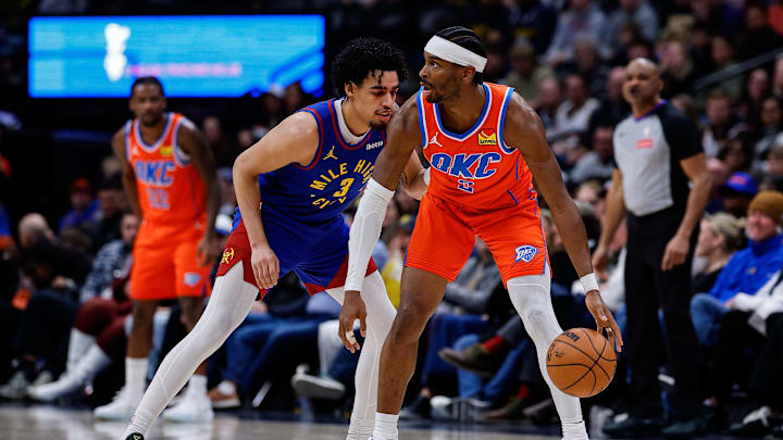 Feb 1, 2026; Denver, Colorado, USA; Oklahoma City Thunder guard Shai Gilgeous-Alexander (2) controls the ball as Denver Nuggets guard Julian Strawther (3) guards in the fourth quarter at Ball Arena. Mandatory Credit: Isaiah J. Downing-Imagn Images