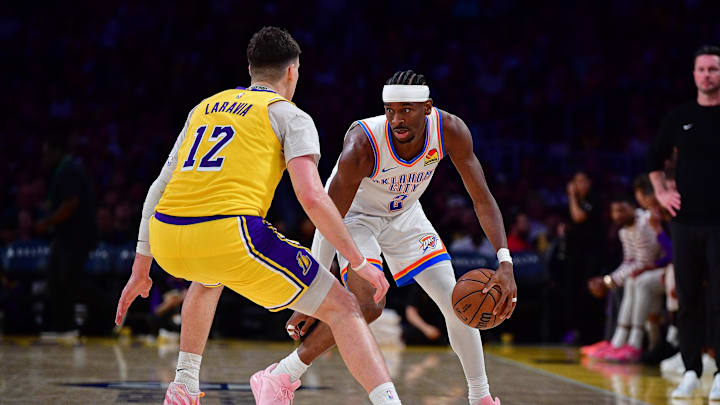 April 7, 2026; Los Angeles, California, USA; Oklahoma City Thunder guard Shai Gilgeous-Alexander (2) moves the ball against Los Angeles Lakers forward Jake LaRavia (12) during the second half at Crypto.com Arena. Mandatory Credit: Gary A. Vasquez-Imagn Images