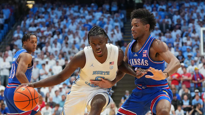 Nov 7, 2025; Chapel Hill, North Carolina, USA;  North Carolina Tar Heels forward Caleb Wilson (8) with the ball as Kansas Jayhawks forward Samis Calderon (6) defends in the second half at Dean E. Smith Center. Mandatory Credit: Bob Donnan-Imagn Images
