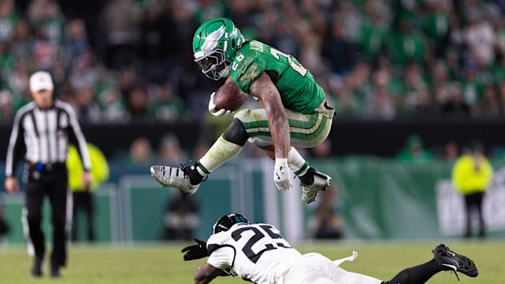 Nov 3, 2024; Philadelphia, Pennsylvania, USA; Philadelphia Eagles running back Saquon Barkley (26) leaps over Jacksonville Jaguars cornerback Ronald Darby (25) while running with the ball during the fourth quarter at Lincoln Financial Field. Mandatory Credit: Bill Streicher-Imagn Images
