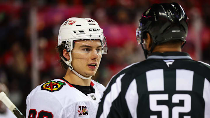 Nov 7, 2025; Calgary, Alberta, CAN; Chicago Blackhawks center Connor Bedard (98) exchanges words with linesman Shandor Alphonso (52) during the second period at Scotiabank Saddledome. Mandatory Credit: Sergei Belski-Imagn Images