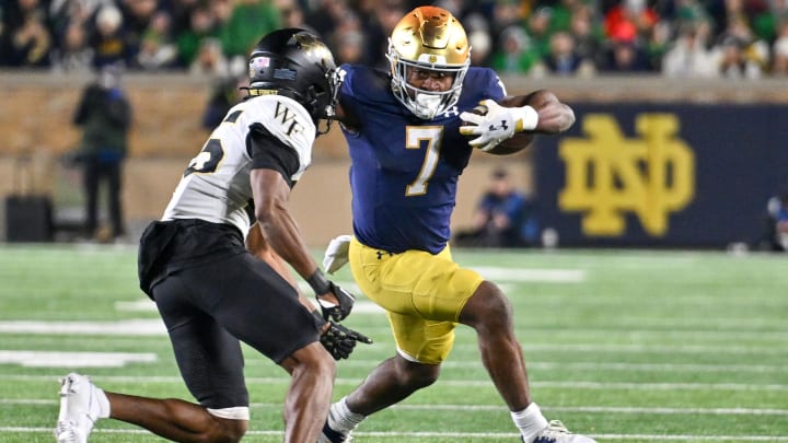 Nov 18, 2023; South Bend, Indiana, USA; Notre Dame Fighting Irish running back Audric Estime (7) runs the ball as Wake Forest Demon Deacons cornerback Jamare Glasker (25) defends in the fourth quarter at Notre Dame Stadium. Mandatory Credit: Matt Cashore-USA TODAY Sports