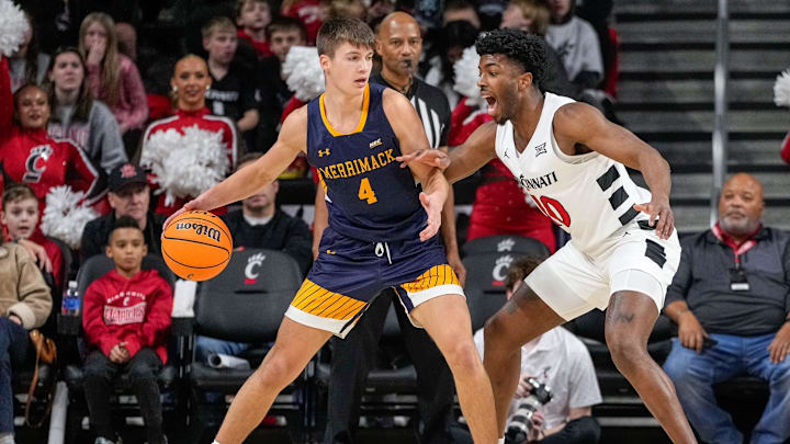 Cincinnati Bearcats guard Josh Reed (10) defends against Merrimack Warriors guard Jordan Derkack (4) in the first half of the NCAA basketball game between the Merrimack Warriors and the Cincinnati Bearcats at Fifth Third Arena in Cincinnati on Tuesday, Dec. 19, 2023.
