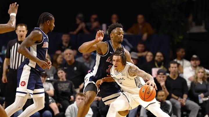 Jan 17, 2026; Orlando, Florida, USA;  Central Florida Knights guard Riley Kugel (2) looks to pass while Arizona Wildcats forward Tobe Awaka (30) defends during the second half at Addition Financial Arena. Mandatory Credit: Russell Lansford-Imagn Images