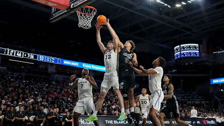 Xavier Musketeers forward Zach Freemantle (32) pulls in a rebound ahead of Cincinnati Bearcats guard Dan Skillings Jr. (0) in the second half of the 92nd Annual Crosstown Shootout NCAA basketball game between the Cincinnati Bearcats and the Xavier Musketeers at Fifth Third Arena on the UC campus in Cincinnati on Saturday, Dec. 14, 2024. The Bearcats won 68-65. Xavier Musketeers forward Zach Freemantle (32) pulls in a rebound ahead of Cincinnati Bearcats guard Dan Skillings Jr. (0) in the second half of the 92nd Annual Crosstown Shootout NCAA basketball game between the Cincinnati Bearcats and the Xavier Musketeers at Fifth Third Arena on the UC campus in Cincinnati on Saturday, Dec. 14, 2024. The Bearcats won 68-65.