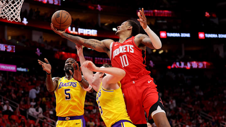 May 1, 2026; Houston, Texas, USA; Houston Rockets forward Jabari Smith Jr. (10) rebounds against Los Angeles Lakers guard Austin Reaves (15) during the first quarter game six of the first round of the 2026 NBA Playoffs at Toyota Center. Mandatory Credit: Erik Williams-Imagn Images