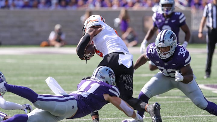 Sep 28, 2024; Manhattan, Kansas, USA; Oklahoma State Cowboys running back Ollie Gordon II (0) is tackled by Kansas State Wildcats linebacker Desmond Purnell (32) and linebacker Austin Moore (41) during the first quarter at Bill Snyder Family Football Stadium. Mandatory Credit: Scott Sewell-Imagn Images