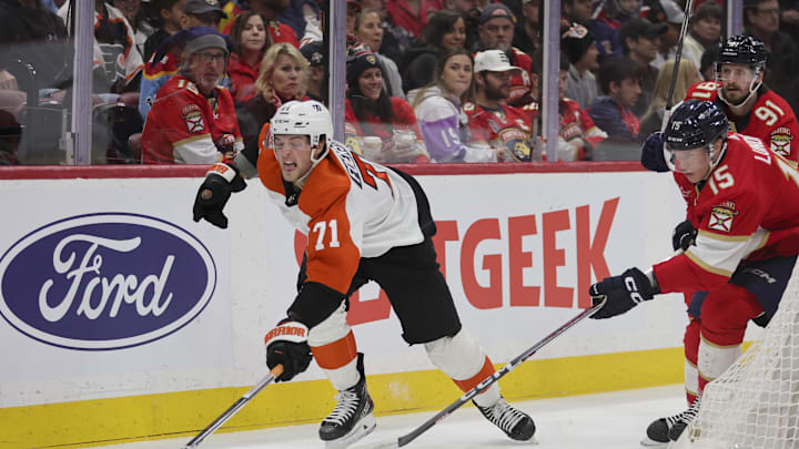 Feb 6, 2024; Sunrise, Florida, USA; Philadelphia Flyers right wing Tyson Foerster (71) reaches for the puck against Florida Panthers center Anton Lundell (15) during the first period at Amerant Bank Arena. Mandatory Credit: Sam Navarro-Imagn Images