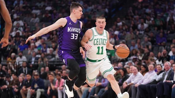 Mar 24, 2025; Sacramento, California, USA; Boston Celtics guard Payton Pritchard (11) dribbles the ball next to Sacramento Kings forward Jake LaRavia (33) in the first quarter at the Golden 1 Center. Mandatory Credit: Cary Edmondson-Imagn Images