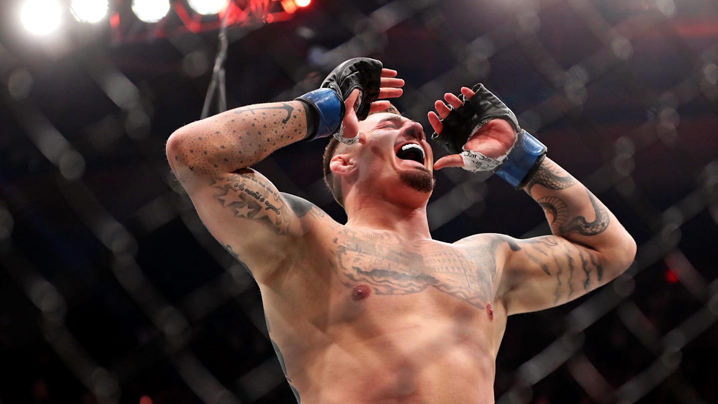 Tom Aspinall (blue gloves) reacts to beating Sergei Pavlovich (red gloves) during UFC 295 at Madison Square Garden.