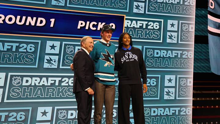 Jun 26, 2026; Buffalo, New York, USA; Keaton Verhoeff reacts beside NHL commissioner Gary Bettman and PWHL San Jose player Laila Edwards after being selected with the ninth pick in the first round of the 2026 NHL Draft by the San Jose Sharks at KeyBank Center. Mandatory Credit: Timothy T. Ludwig-Imagn Images