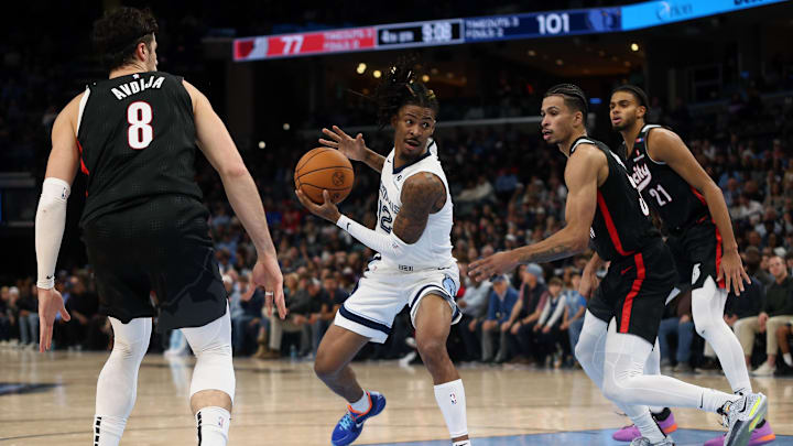 Nov 25, 2024; Memphis, Tennessee, USA; Memphis Grizzlies guard Ja Morant (12) drives to the basket between Portland Trail Blazers forward Deni Avdija (8) and forward Toumani Camara (33) during the second half at FedExForum. Mandatory Credit: Petre Thomas-Imagn Images