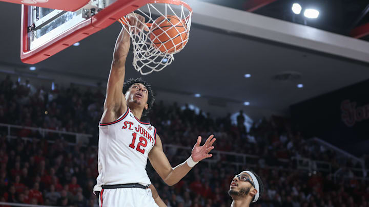 Jan 4, 2025; Queens, New York, USA;  St. John's basketball guard RJ Luis Jr. (12) drives past Butler Bulldogs center Andre Screen (23) for a dunk in the second half at Carnesecca Arena. 