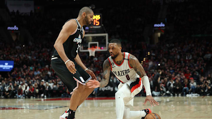 Mar 19, 2023; Portland, Oregon, USA; Portland Trail Blazers guard Damian Lillard (0) dribbles the ball past LA Clippers forward Nicolas Batum (33) in the second half at Moda Center. Mandatory Credit: Jaime Valdez-Imagn Images