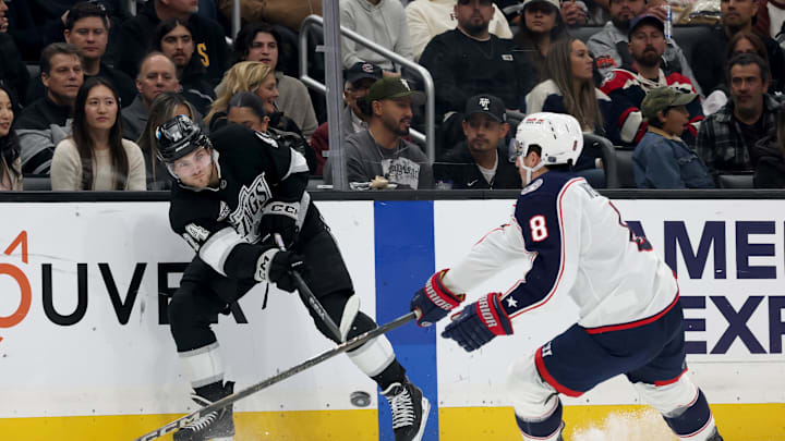 Nov 9, 2024; Los Angeles, California, USA; Los Angeles Kings right wing Alex Laferriere (14) passes against Columbus Blue Jackets defenseman Zach Werenski (8) during the second period at Crypto.com Arena. Mandatory Credit: Jason Parkhurst-Imagn Images