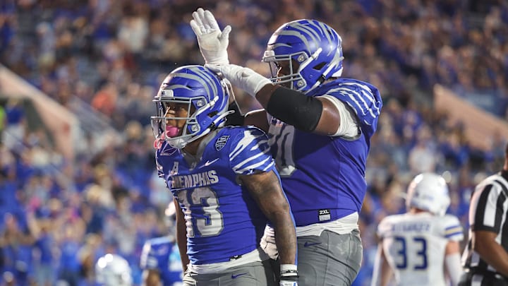 Oct 4, 2025; Memphis, Tennessee, USA; Memphis Tigers running back Greg Desrosiers Jr. (13) and offensive lineman Parker Mitchell (70) celebrate after a touchdown against the Tulsa Golden Hurricane during the second half at Simmons Bank Liberty Stadium. Mandatory Credit: Wesley Hale-Imagn Images