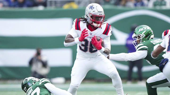 Dec 28, 2025; East Rutherford, New Jersey, USA; New England Patriots running back Rhamondre Stevenson (38) runs for a first down against New York Jets safety Malachi Moore (27) during the first quarter of the game at MetLife Stadium. Mandatory Credit: Robert Deutsch-Imagn Images