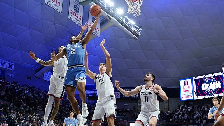 Nov 10, 2025; Storrs, Connecticut, USA; Columbia Lions guard Kenny Noland (2) shoots against UConn Huskies center Eric Reibe (12) in the first half at Harry A. Gampel Pavilion. Mandatory Credit: David Butler II-Imagn Images Nov 10, 2025; Storrs, Connecticut, USA; Columbia Lions guard Kenny Noland (2) shoots against UConn Huskies center Eric Reibe (12) in the first half at Harry A. Gampel Pavilion. Mandatory Credit: David Butler II-Imagn Images