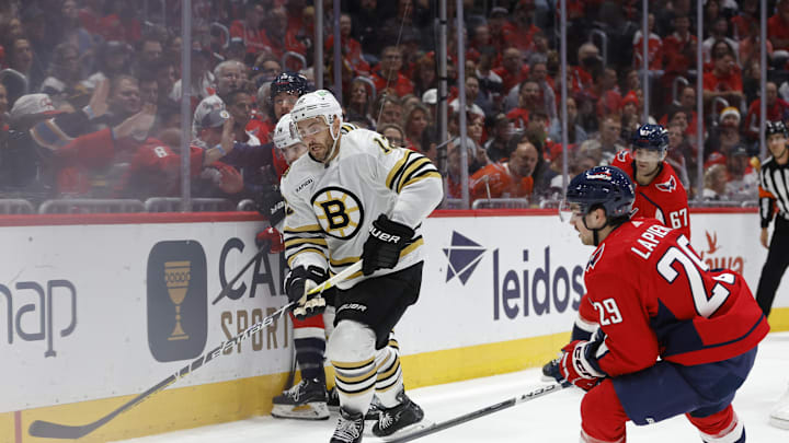 Apr 15, 2024; Washington, District of Columbia, USA; Boston Bruins defenseman Kevin Shattenkirk (12) skates with the puck as Washington Capitals center Hendrix Lapierre (29) defends in the third period at Capital One Arena. Mandatory Credit: Geoff Burke-USA TODAY Sports