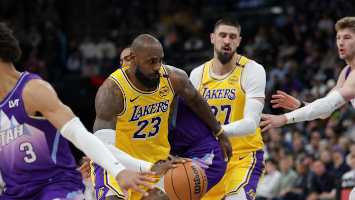 Feb 12, 2025; Salt Lake City, Utah, USA;  Los Angeles Lakers forward LeBron James (23) tries to spin around Utah Jazz forward John Collins (20) during the second quarter at Delta Center. Mandatory Credit: Chris Nicoll-Imagn Images