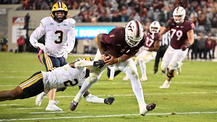 Oct 24, 2025; Blacksburg, Va.; California defensive back Dru Polidore Jr. (2) attempts to stop Virginia Tech quarterback Kyron Drones (1).