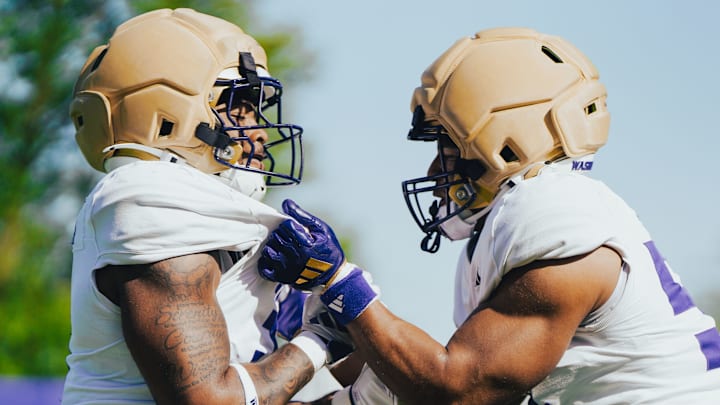 Buddah Al-Uqdah, left, and Anthony Ward engage in a UW linebacker drill.