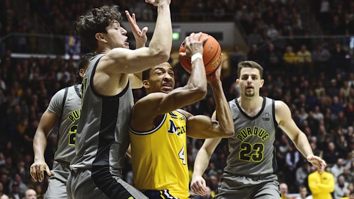 Michigan Wolverines guard Nimari Burnett (4) drives to basket as Purdue Boilermakers forward Raleigh Burgess (34) defends during the first half at Mackey Arena.