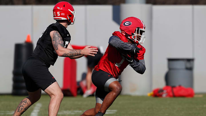 Georgia running back Trevor Etienne (1) takes a handoff from Georgia quarterback Carson Beck (15)