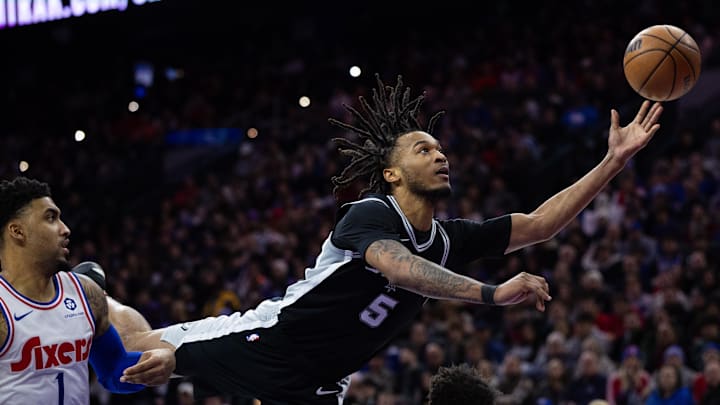 San Antonio Spurs guard Stephon Castle (5) commits an offensive foul while driving for a shot against the Philadelphia 76ers during the third quarter at Wells Fargo Center.