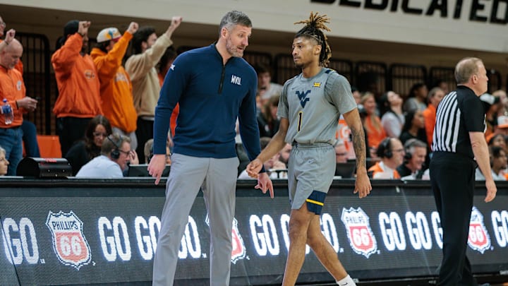 Jan 27, 2024; Stillwater, Oklahoma, USA; West Virginia Mountaineers guard Noah Farrakhan (1) speaks to head coach Josh Eilert.