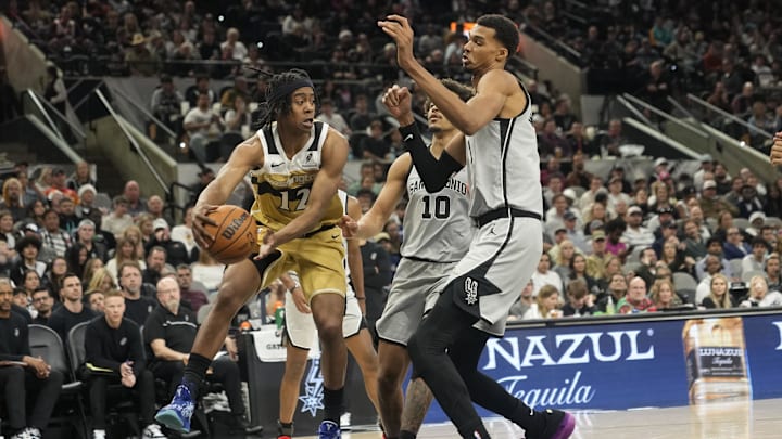 Dec 18, 2025; San Antonio, Texas, USA; Washington Wizards guard Tre Johnson (12) looks to pass against San Antonio Spurs forward Victor Wembanyama (1) during the second half at Frost Bank Center. Mandatory Credit: Scott Wachter-Imagn Images