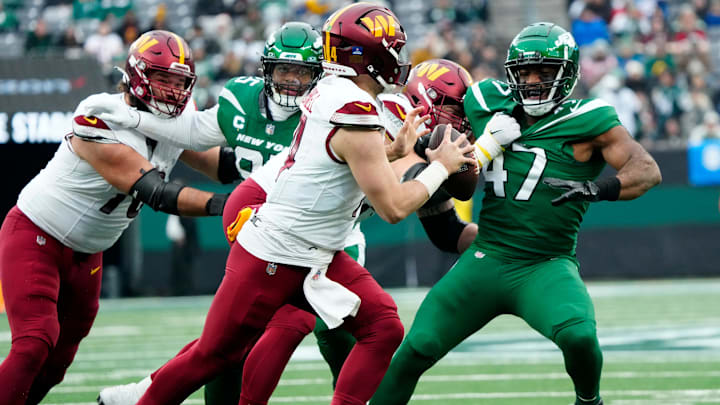 Washington Commanders quarterback Sam Howell (14) looks for an open teammate as New York Jets