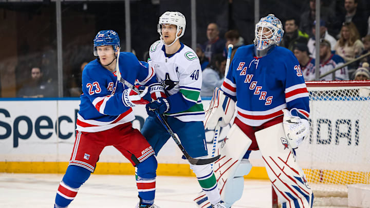 Mar 22, 2025; New York, New York, USA; New York Rangers defenseman Adam Fox (23) and Vancouver Canucks center Elias Pettersson (40) battle for position in front of New York Rangers goalie Igor Shesterkin (31) during the second period at Madison Square Garden. Mandatory Credit: Danny Wild-Imagn Images