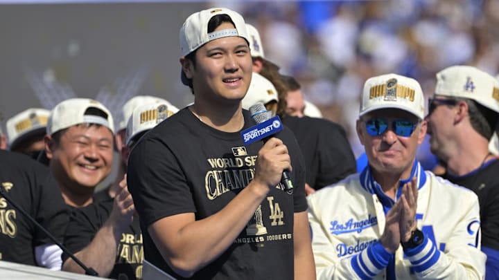 Nov 1, 2024; Los Angeles, CA, USA;  Los Angeles Dodgers owner Stan Kasten applauds as designated hitter Shohei Ohtani speaks to fans, in English, during the World Series Championship Celebration at Dodger Stadium. 