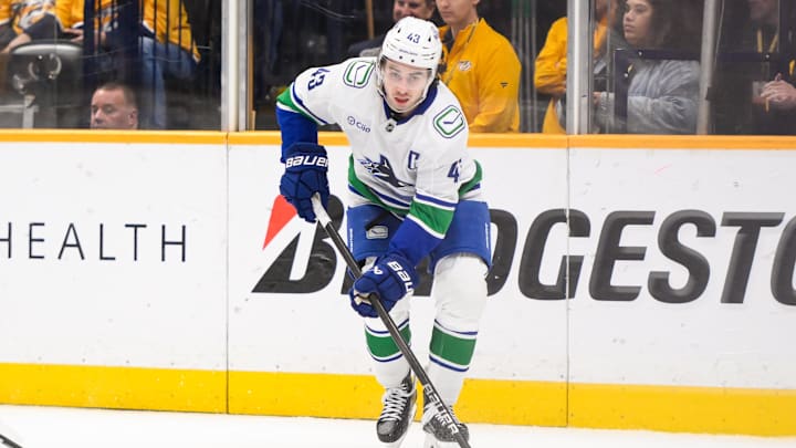Jan 29, 2025; Nashville, Tennessee, USA;  Vancouver Canucks defenseman Quinn Hughes (43) skates behind the net against the Nashville Predators during the third period at Bridgestone Arena. Mandatory Credit: Steve Roberts-Imagn Images