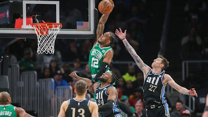 Mar 25, 2024; Atlanta, Georgia, USA; Boston Celtics forward Oshae Brissett (12) attempts a dunk past Atlanta Hawks forward Bruno Fernando (24) and guard Vit Krejci (27) in the second half at State Farm Arena. Mandatory Credit: Brett Davis-Imagn Images