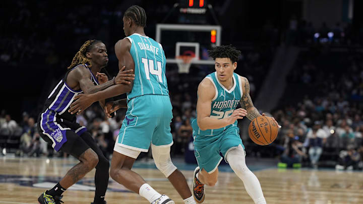 Apr 4, 2025; Charlotte, North Carolina, USA; Charlotte Hornets guard KJ Simpson (25) drives around forward Moussa Diabate (14) blocking Sacramento Kings guard Keon Ellis (23) during the second half at Spectrum Center. Mandatory Credit: Jim Dedmon-Imagn Images