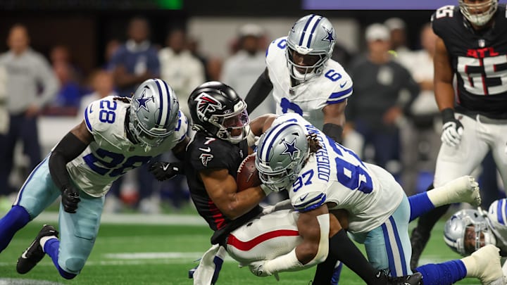 Atlanta Falcons running back Bijan Robinson is tackled by Dallas Cowboys safety Malik Hooker  and defensive tackle Osa Odighizuwa