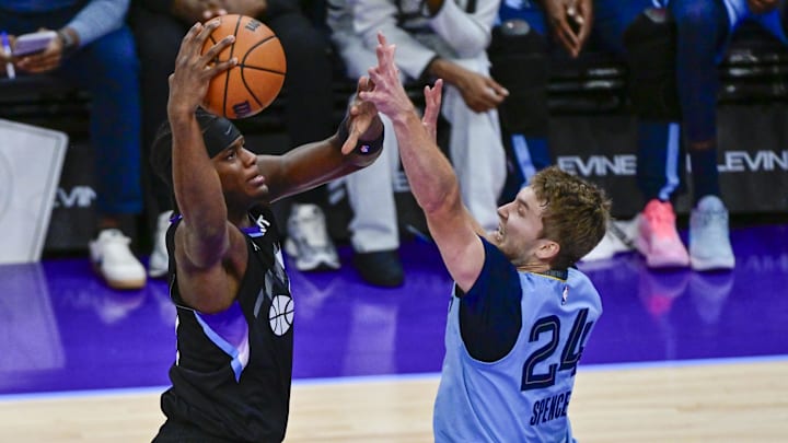 Dec 23, 2025; Salt Lake City, Utah, USA; Utah Jazz forward Taylor Hendricks (0) leaps over Memphis Grizzlies guard Cam Spencer (24) for a layup during the second half at Delta Center. Mandatory Credit: Peter Creveling-Imagn Images