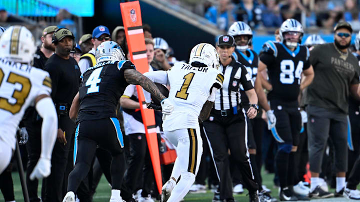 Nov 9, 2025; Charlotte, North Carolina, USA; New Orleans Saints cornerback Alontae Taylor (1) intercepts a pass as Carolina Panthers wide receiver Tetairoa McMillan (4) defends in the fourth quarter at Bank of America Stadium. Mandatory Credit: Bob Donnan-Imagn Images