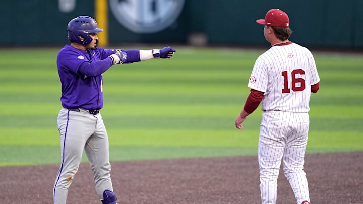 LSU's Luis Hernandez (23) celebrates a double next to Oklahoma's Dayton Tockey (16) during the college baseball game between the University of Oklahoma Sooners and the LSU Tigers at L. Dale Mitchell Park in Norman, Okla., Thursday, April, 3, 2025.