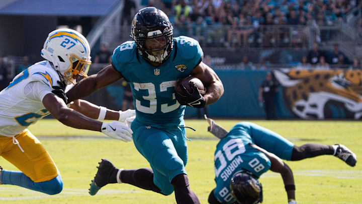 Jacksonville Jaguars running back Bhayshul Tuten (33) eludes a tackle in the second quarter as Los Angeles Chargers safety R.J. Mickens (27) tries to tackle him in an NFL football game at EverBank Stadium, Sunday, November 16, 2025, in Jacksonville, Fla. [Doug Engle/Florida Times-Union]
