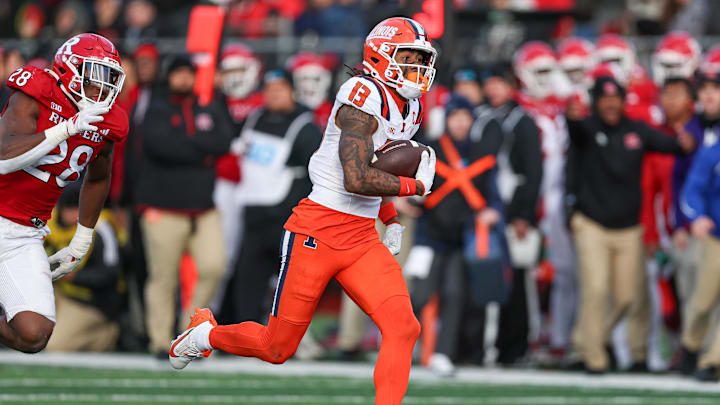 Nov 23, 2024; Piscataway, New Jersey, USA; Illinois Fighting Illini wide receiver Pat Bryant (13) gains yards after catch as linebacker Dariel Djabome (28) pursues during the second half at SHI Stadium. Mandatory Credit: Vincent Carchietta-Imagn Images Nov 23, 2024; Piscataway, New Jersey, USA; Illinois Fighting Illini wide receiver Pat Bryant (13) gains yards after catch as linebacker Dariel Djabome (28) pursues during the second half at SHI Stadium. Mandatory Credit: Vincent Carchietta-Imagn Images